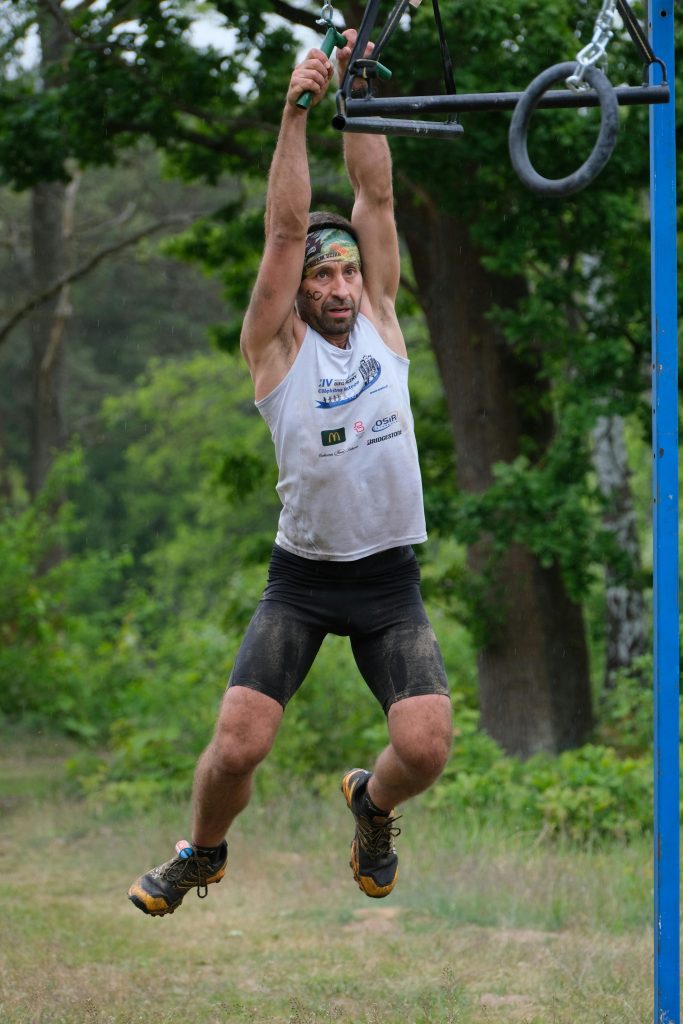 pexels photo 32212441 32212441 A man engaged in a challenging outdoor obstacle course race, demonstrating strength and determination.